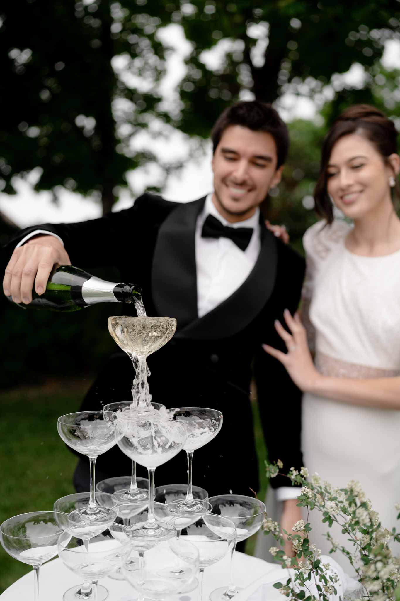Couple pouring champagne into a glass tower at the reception