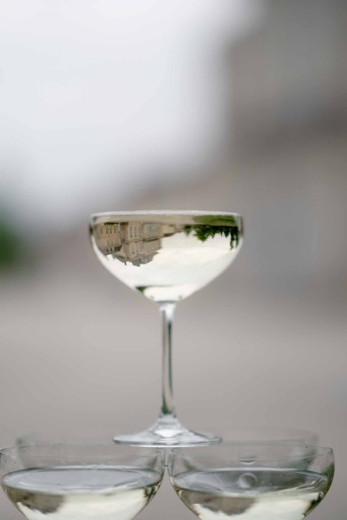 Champagne glass tower with Chateau d'Arcelot reflected in the glasses