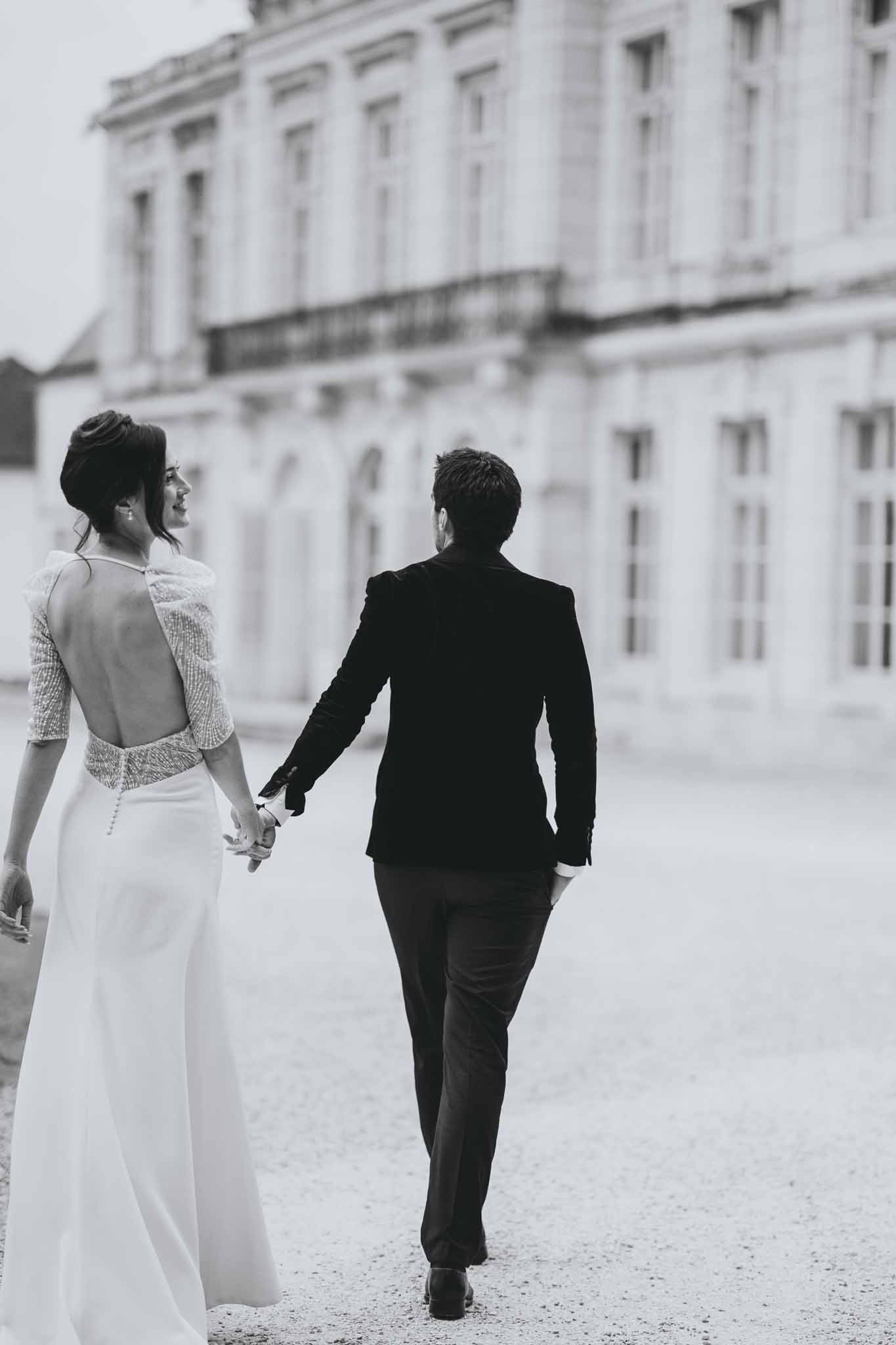 Couple walking hand in hand through the formal gardens of Chateau d'Arcelot