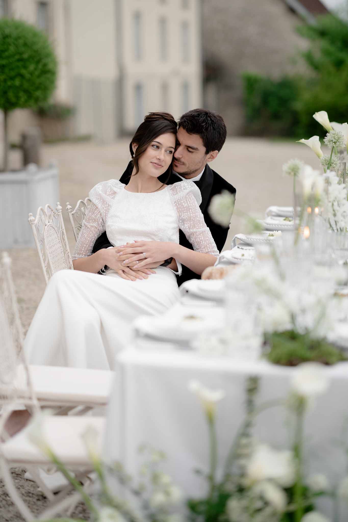 Couple embracing while seated at the reception table
