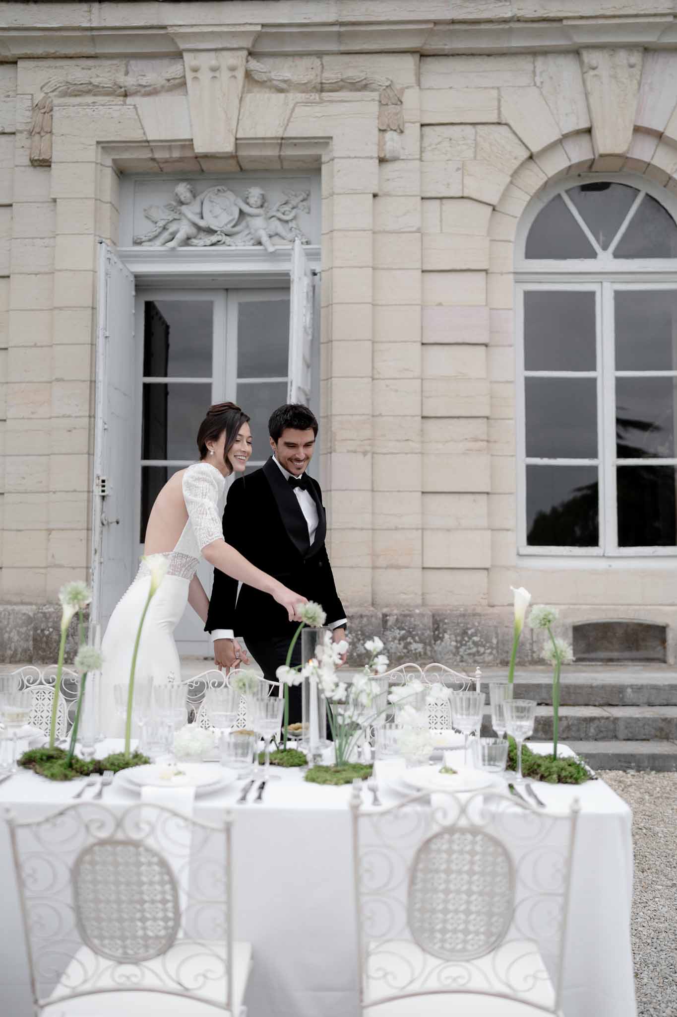 Couple walking around the beautifully set reception table in the garden