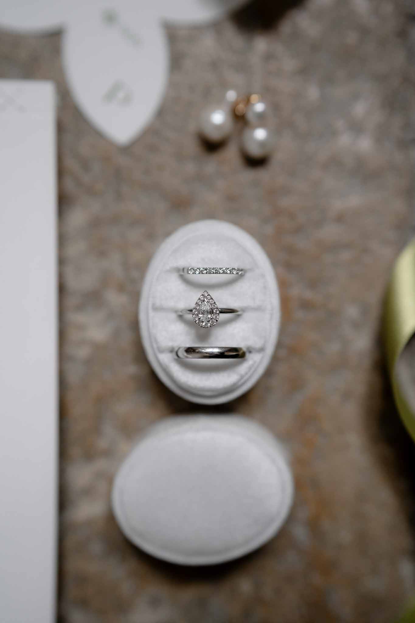 Flatlay arrangement of bridal accessories including rings, earrings, and jewellery box