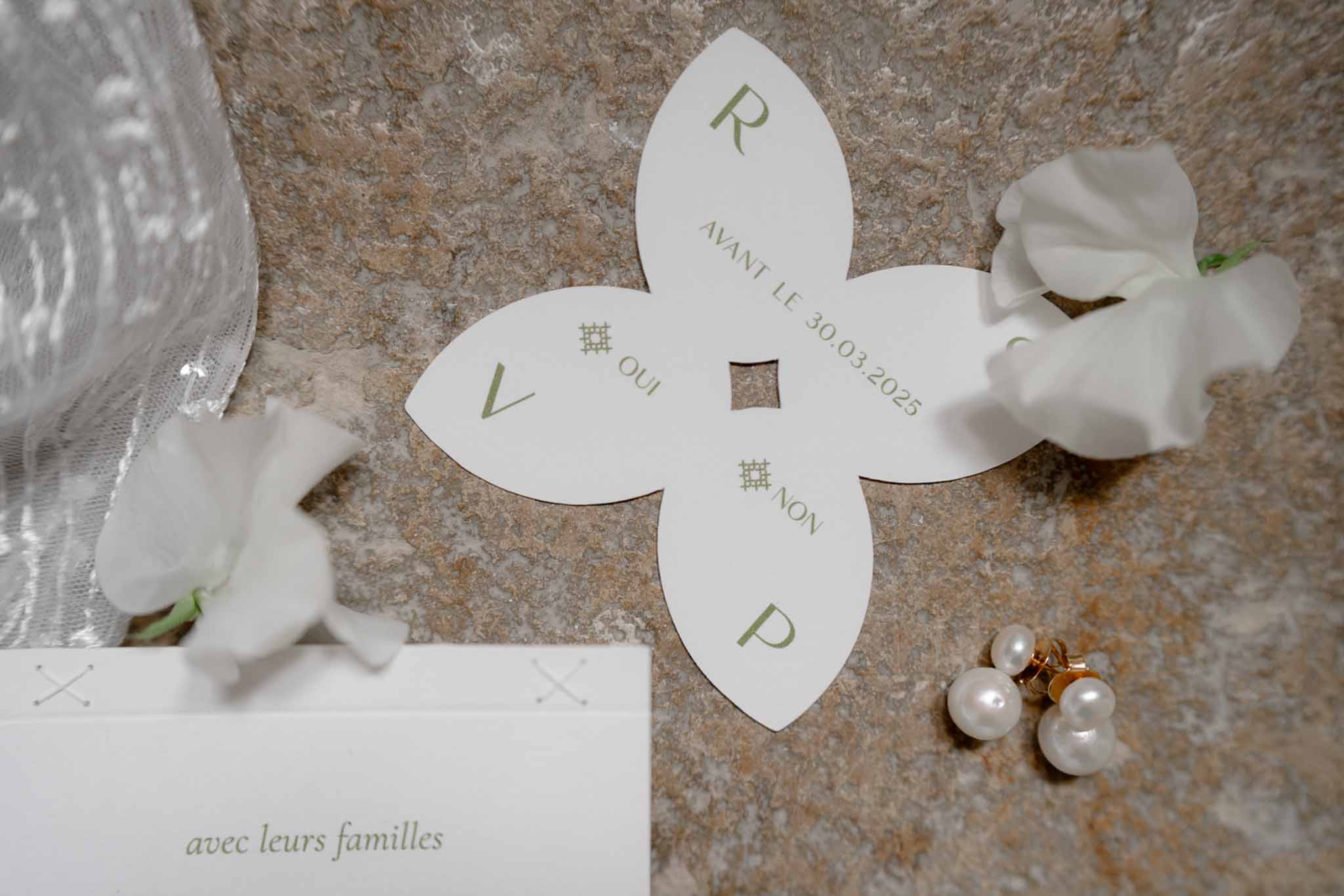Wedding invitation flatlay with a single flower accent