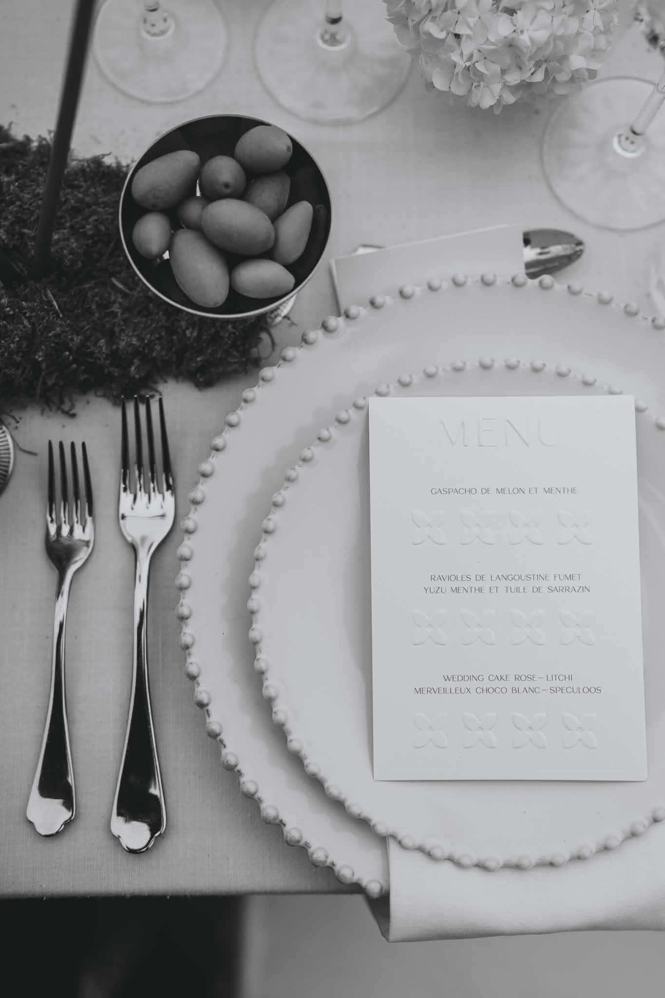 Overhead view of place setting with menu card, tableware, and food