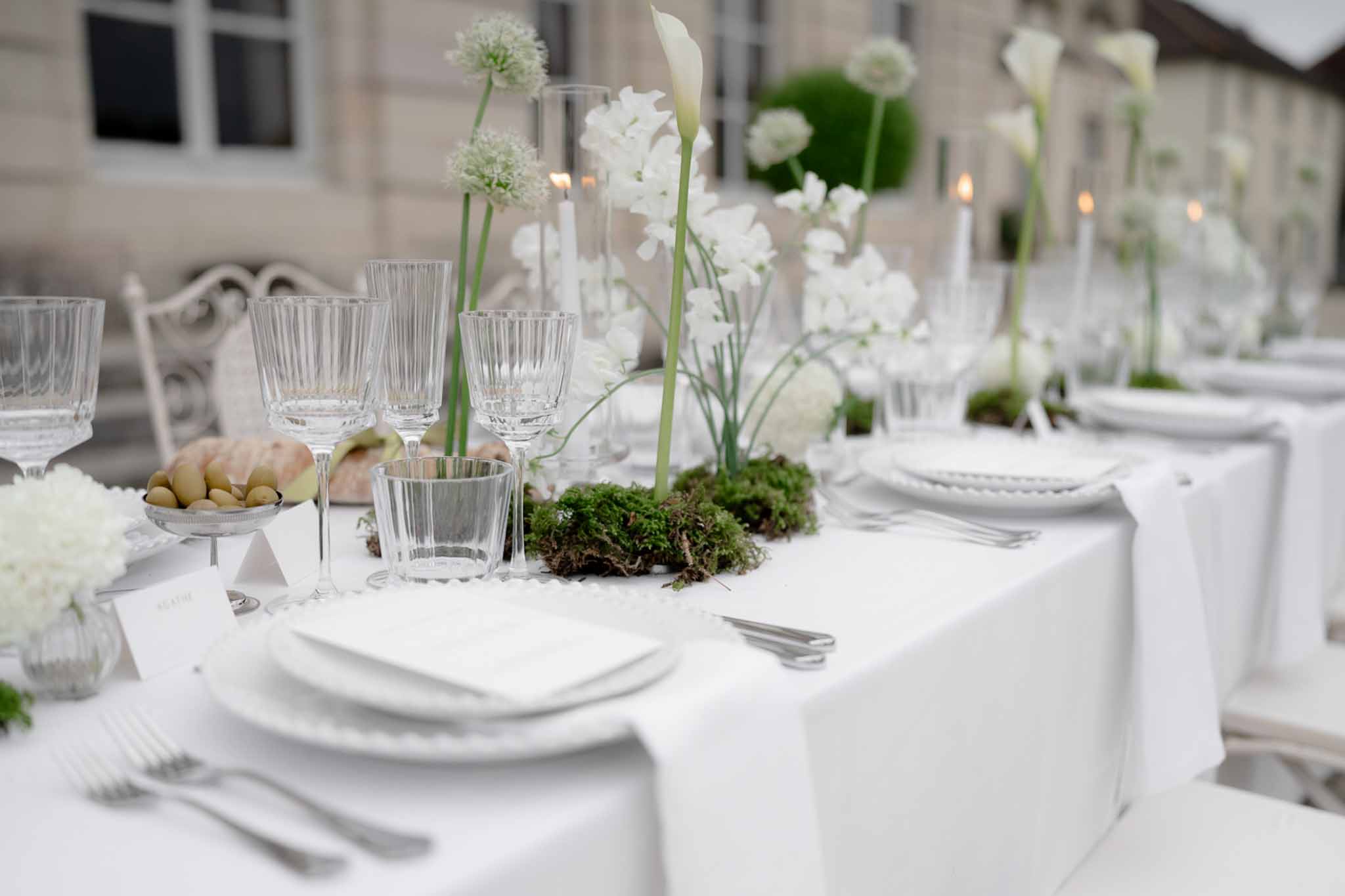 Table setting detail showing centerpiece, flowers, and candlelight