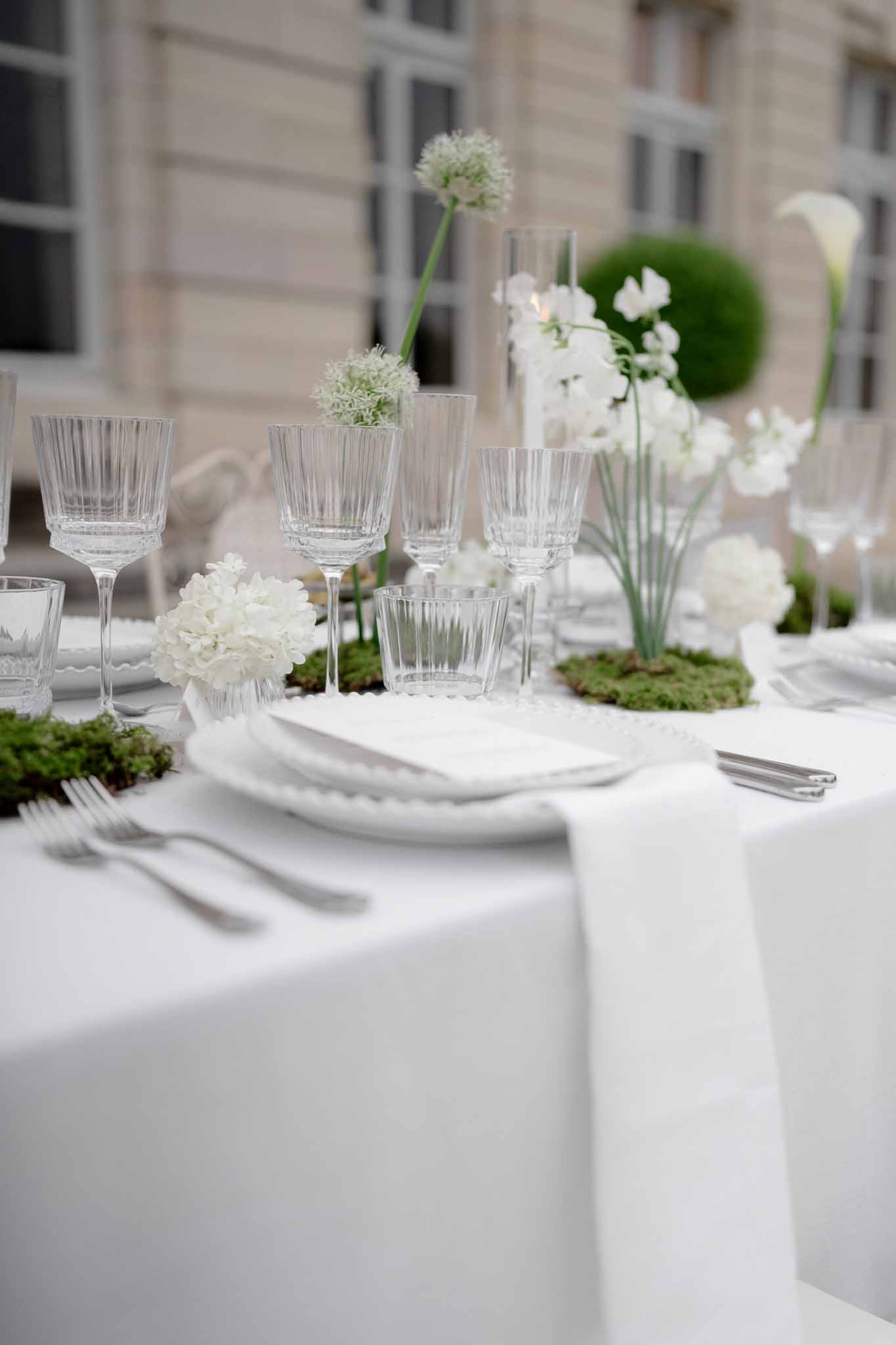 Close-up of elegant tableware, crystal glasses, and floral arrangements
