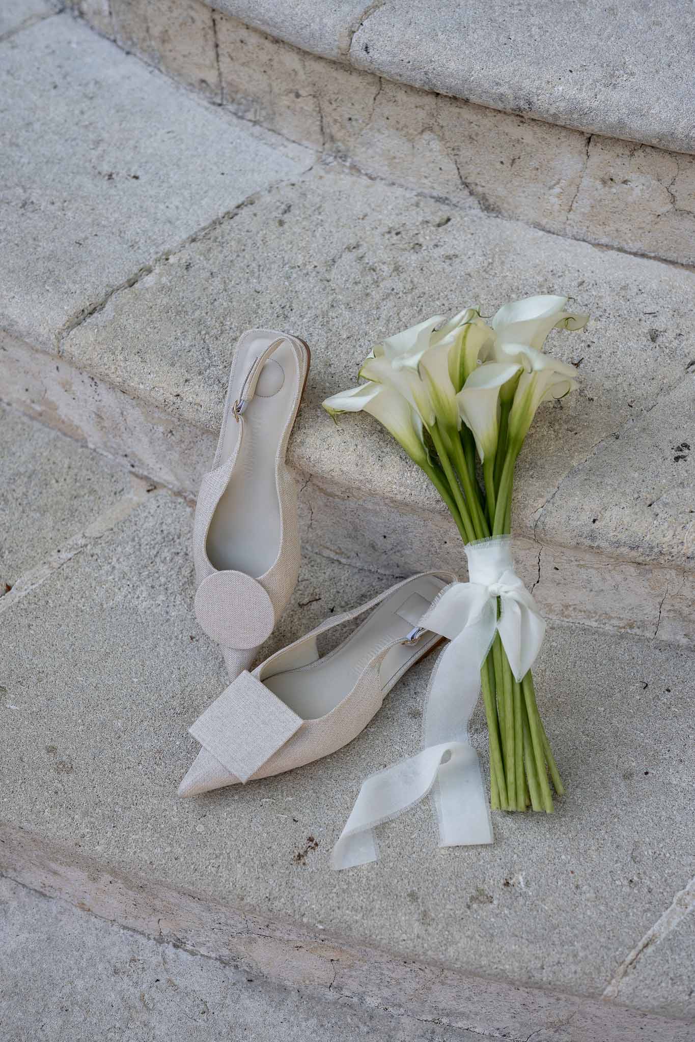 Calla lily bridal bouquet with white pointed shoes detail shot