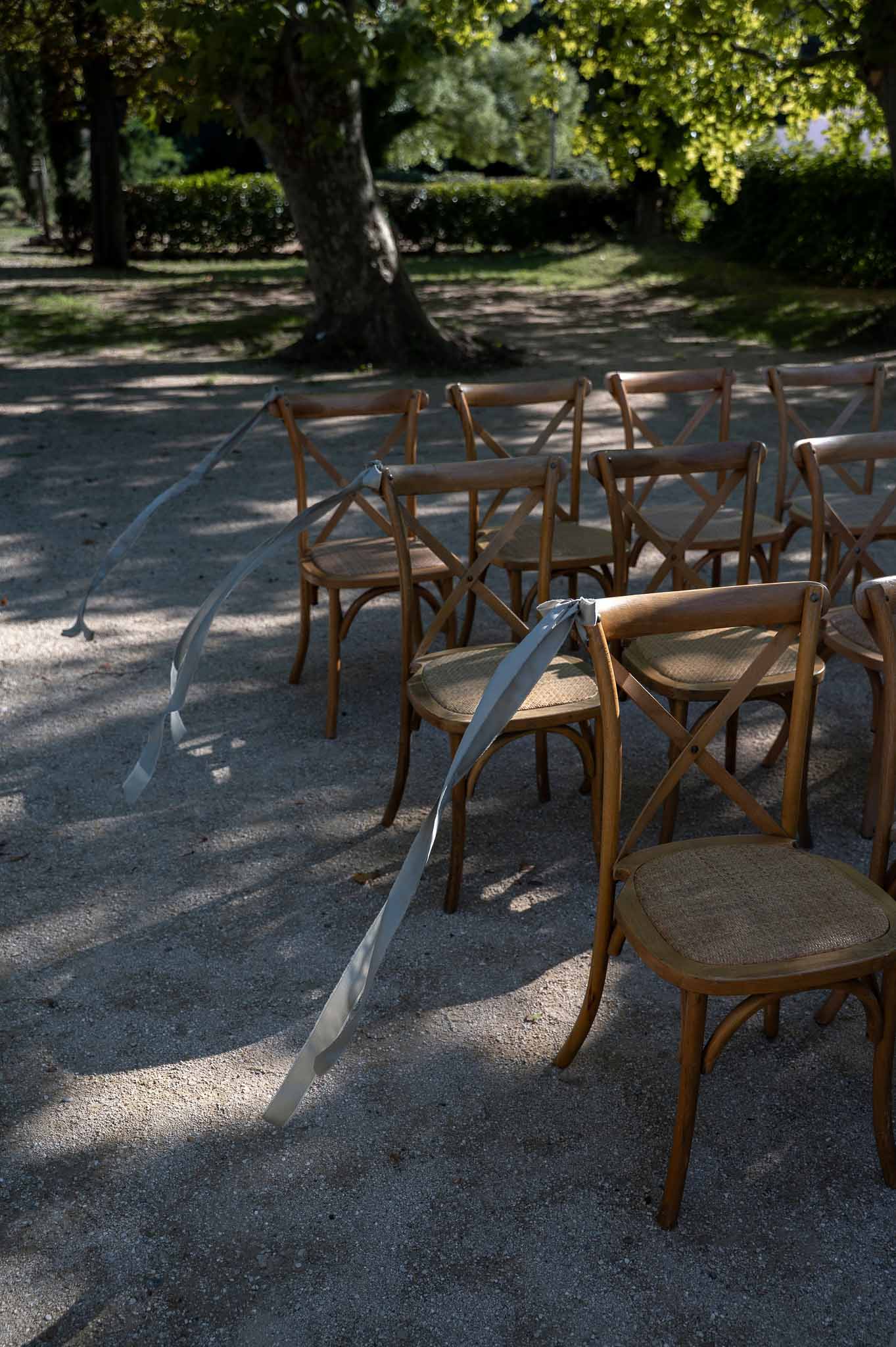 Rows of wooden chairs arranged along outdoor ceremony aisle at Notre-Dame de Conil