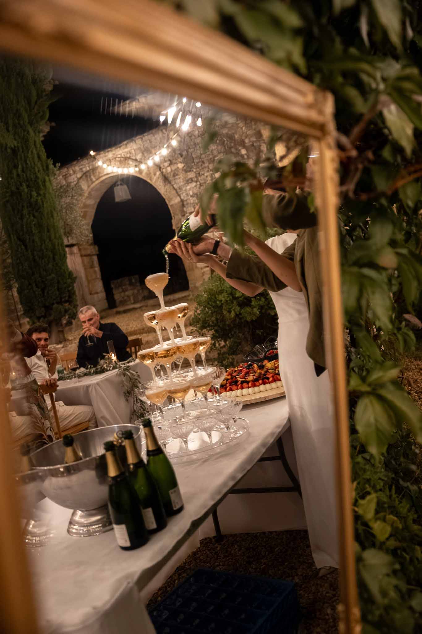 Couple pouring champagne over a glass tower at the wedding reception