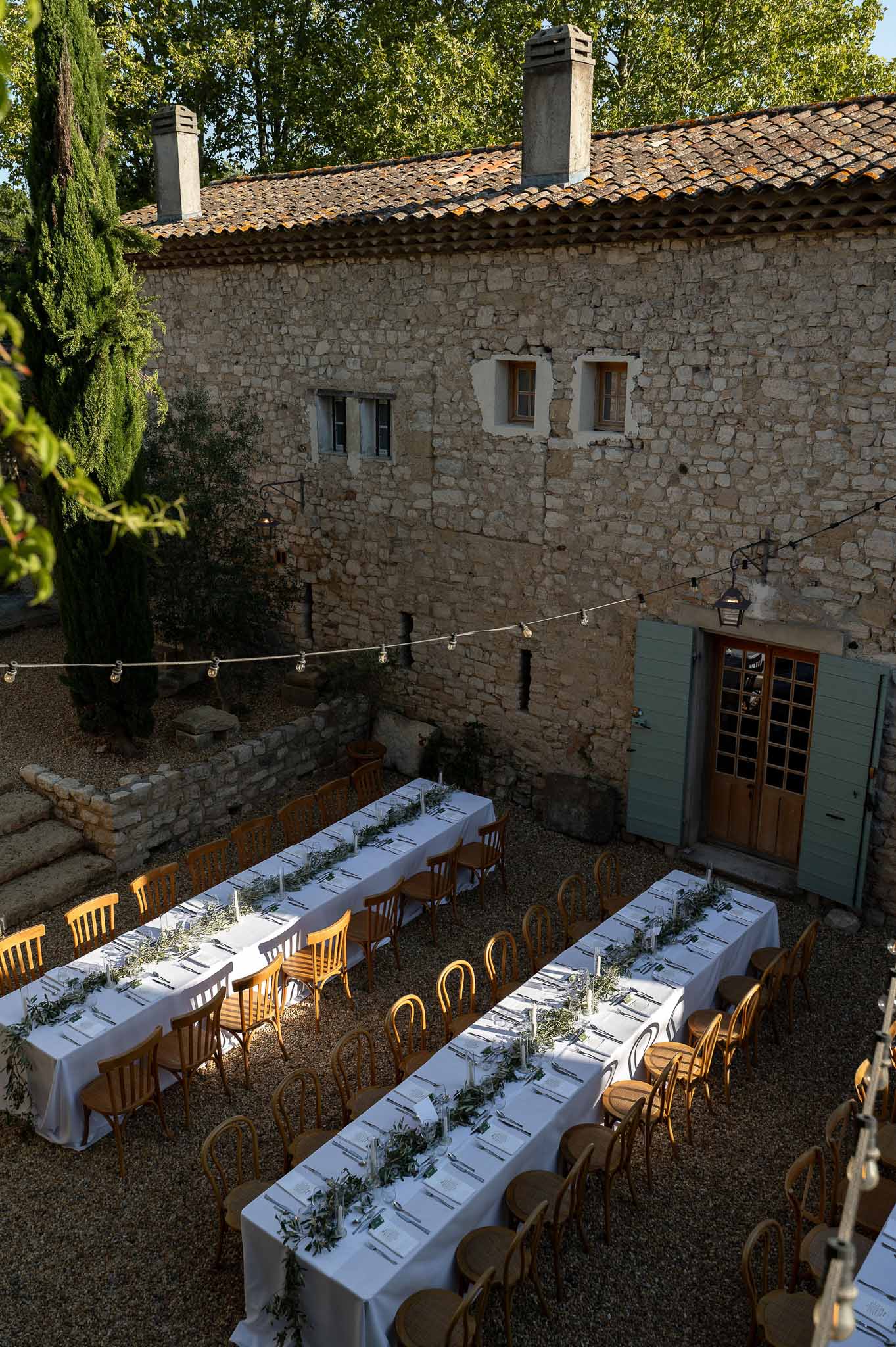 Aerial view of reception tablescape with wooden chairs and olive branch centrepieces