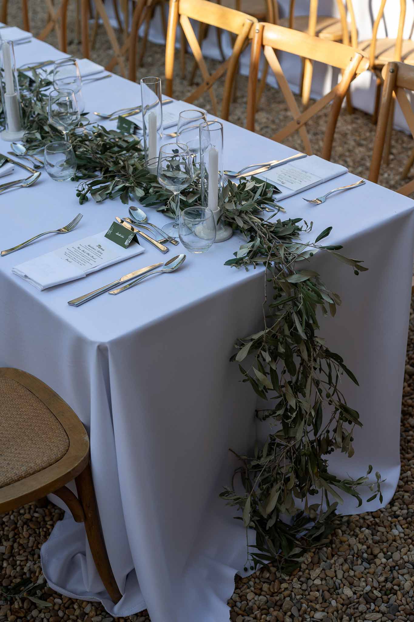 Reception place setting with menu card, napkin and olive leaf centrepiece detail