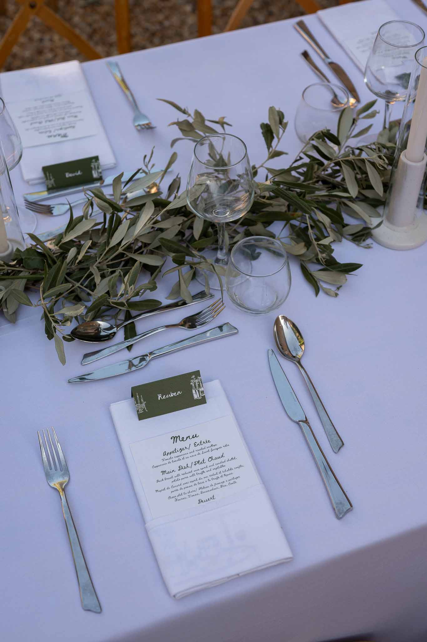 Reception place setting with menu card, linen napkin and olive branch centrepiece