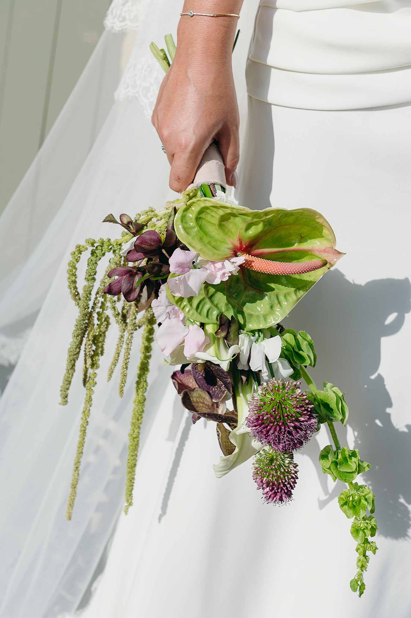 Bride holding a wild flower bouquet at Domaine de Perrotin