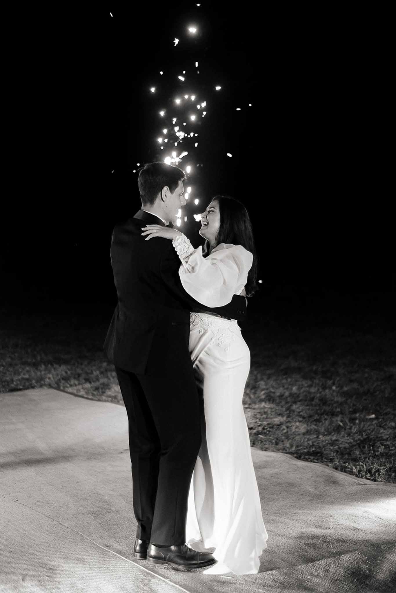 Bride and groom dancing at the reception as fireworks light the sky at Domaine de Perrotin