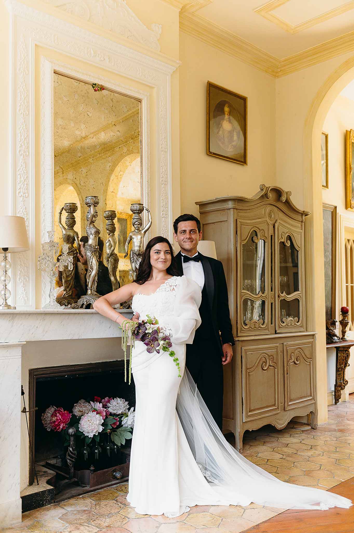 Bride and groom posing together by the vintage chimney at Domaine de Perrotin