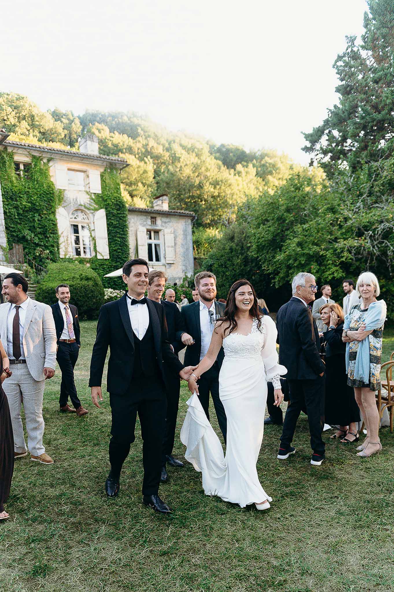 Bride and groom entering the reception holding hands at Domaine de Perrotin