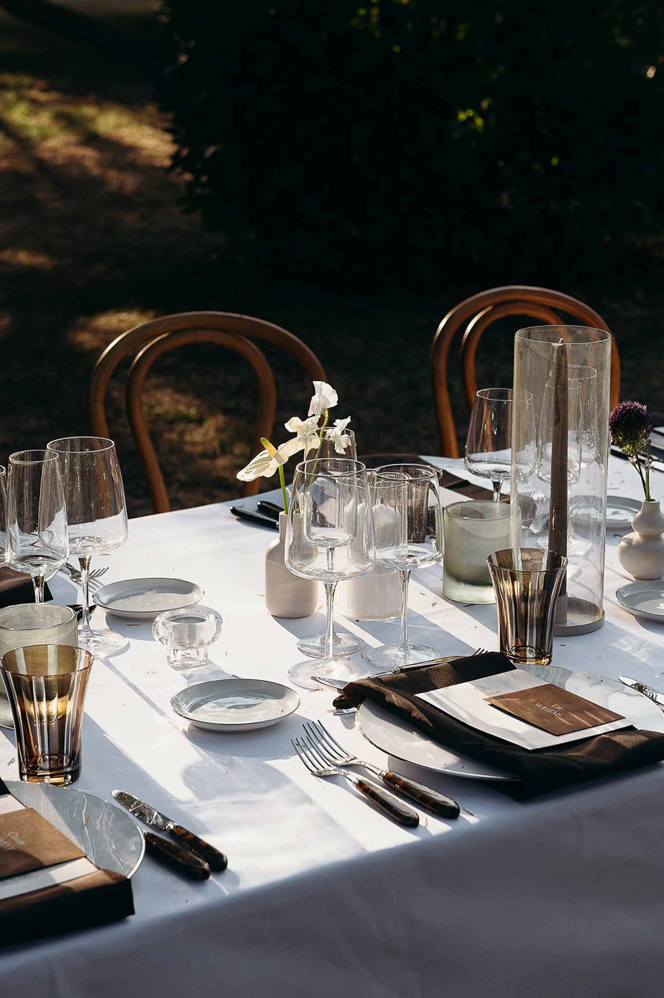 Centrepiece featuring tableware, flower vase, and brown-toned glasses at Domaine de Perrotin
