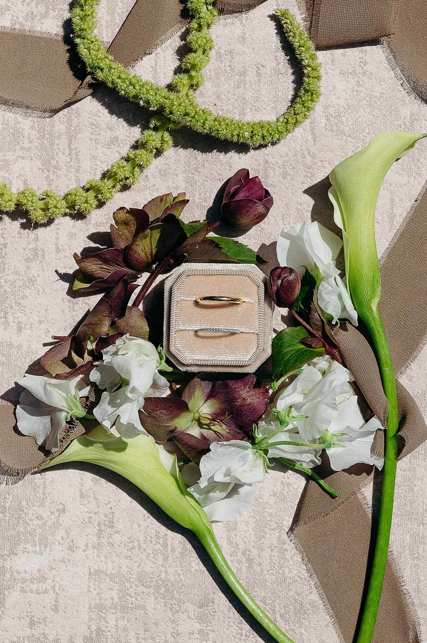 Flat lay of wedding accessories including diamond ring and flowers at Domaine de Perrotin