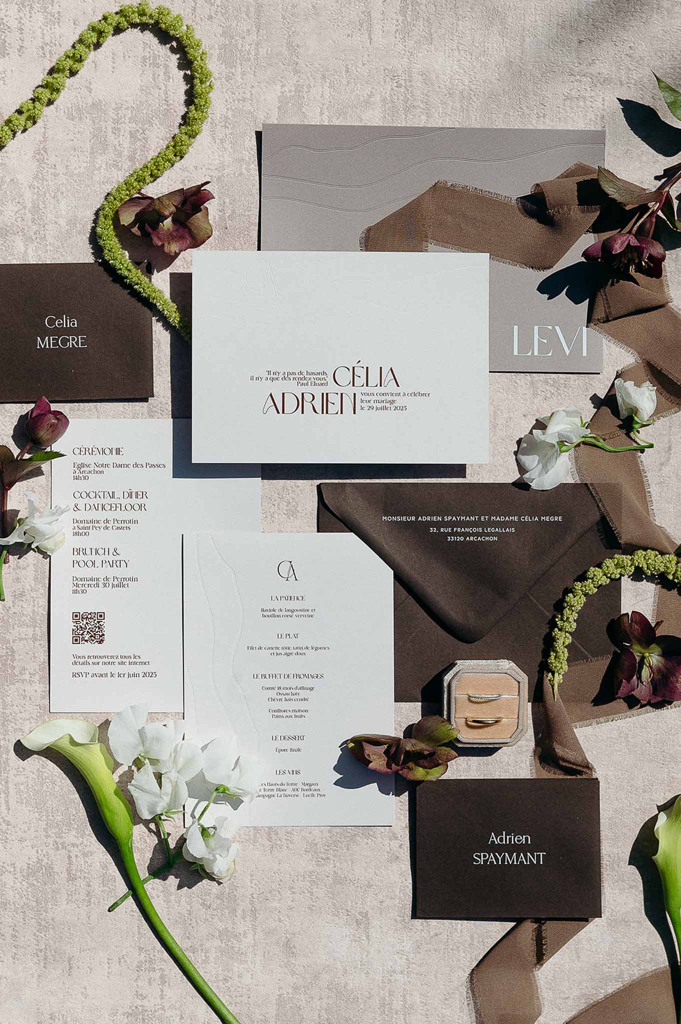 Flat lay of wedding invitation with brown flower theme at Domaine de Perrotin