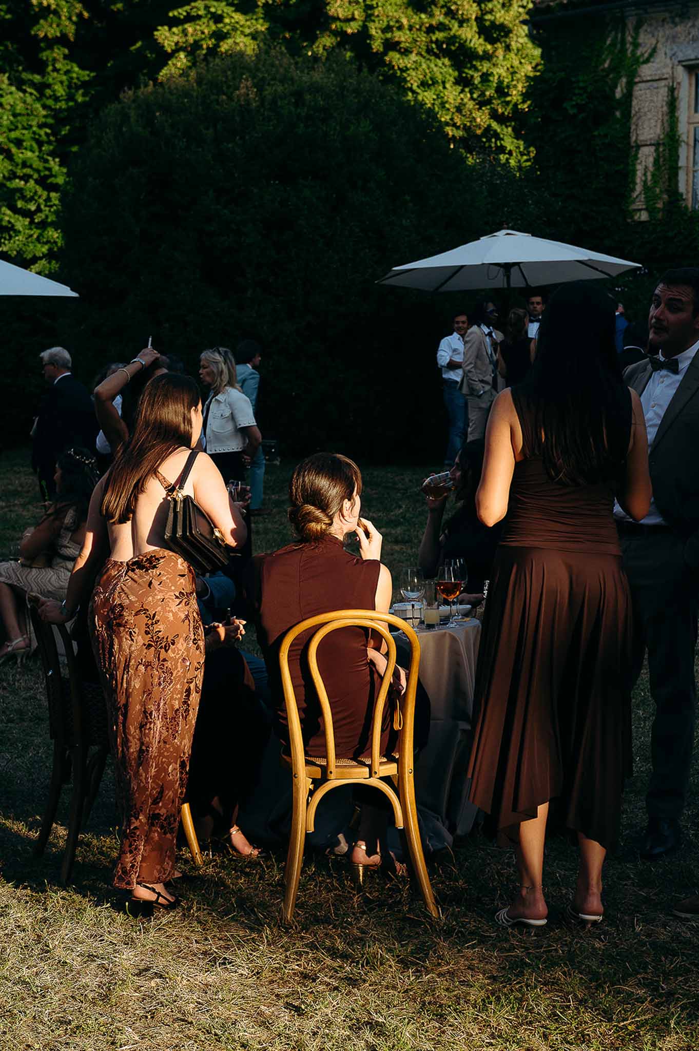 Bridal party gathered in the cocktail garden area during golden hour at Domaine de Perrotin