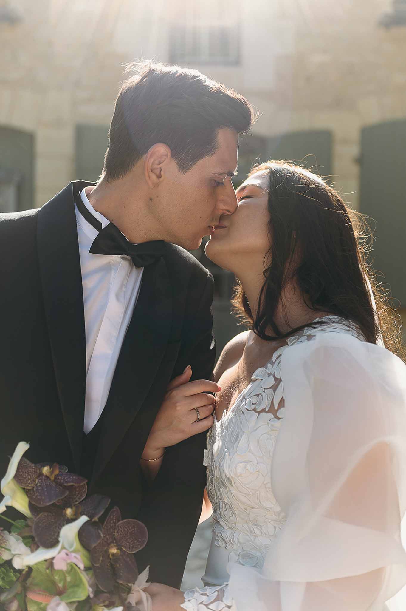 Close-up of couple kissing and hugging during golden hour at Domaine de Perrotin