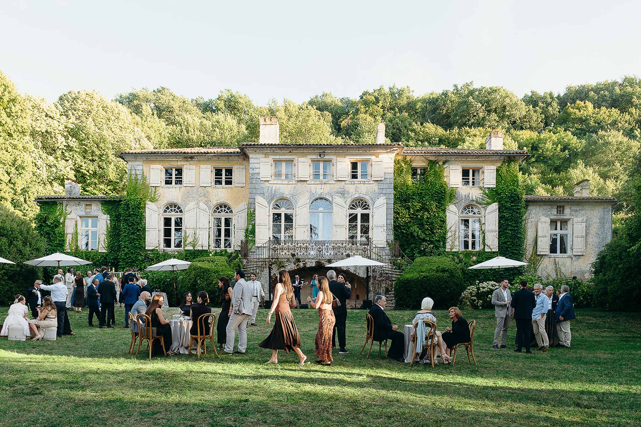Guests enjoying the cocktail garden area during golden hour at Domaine de Perrotin