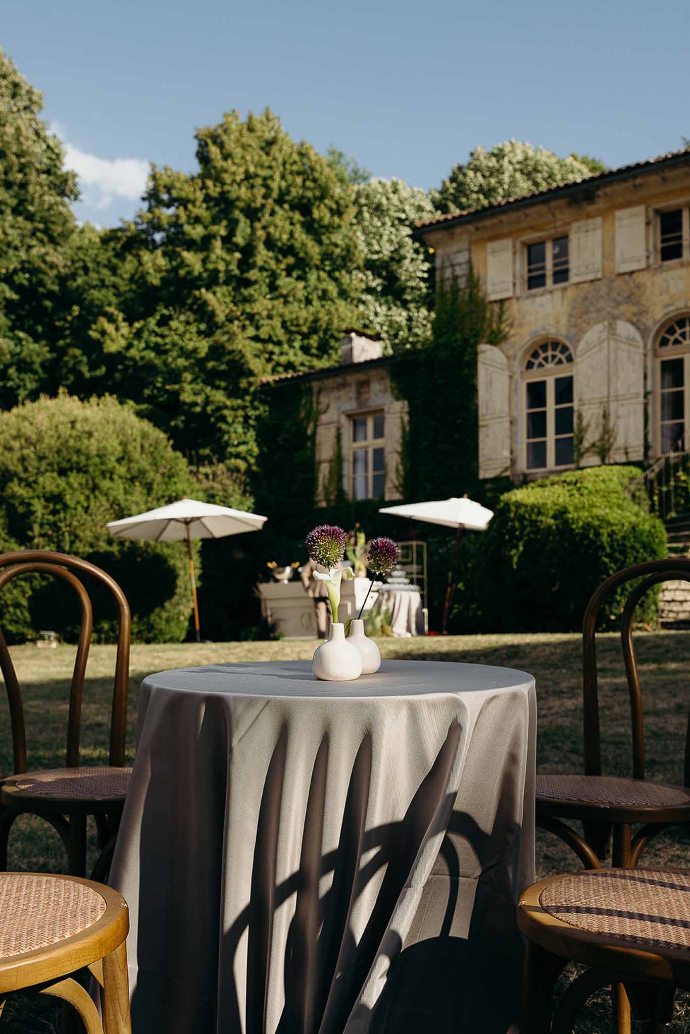 Tables and chairs with flower vases during golden hour at Domaine de Perrotin