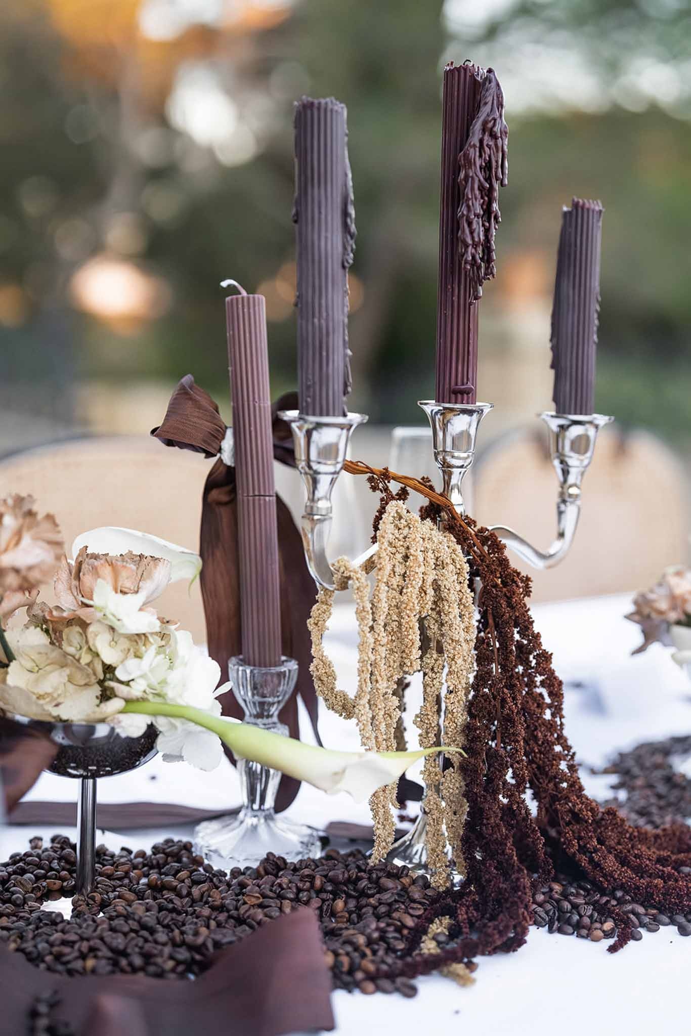 Silver candelabra with dark candles and dried amaranth centrepiece at Chateau du Terral