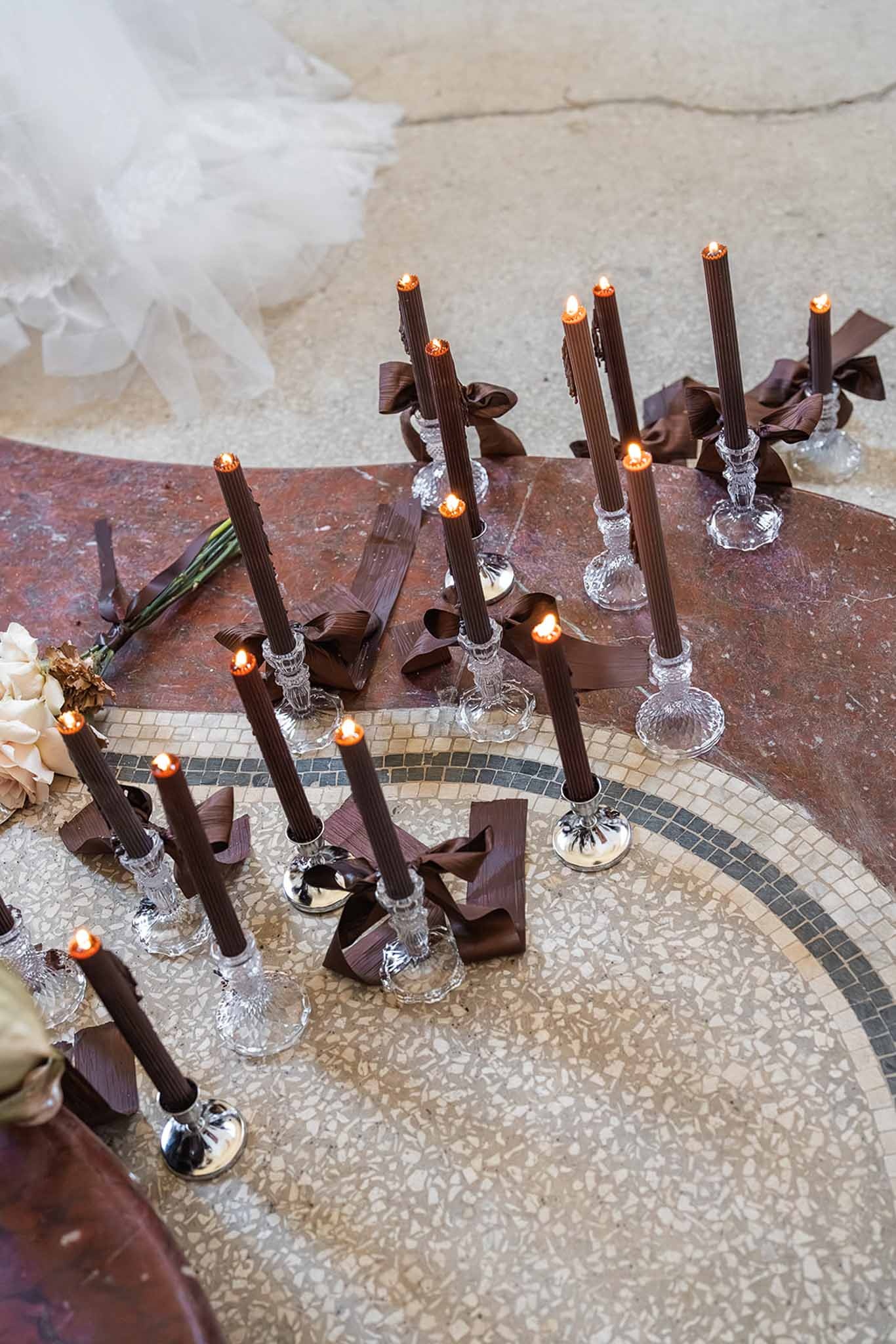 Dark tapered candles on mosaic floor at Chateau du Terral ceremony