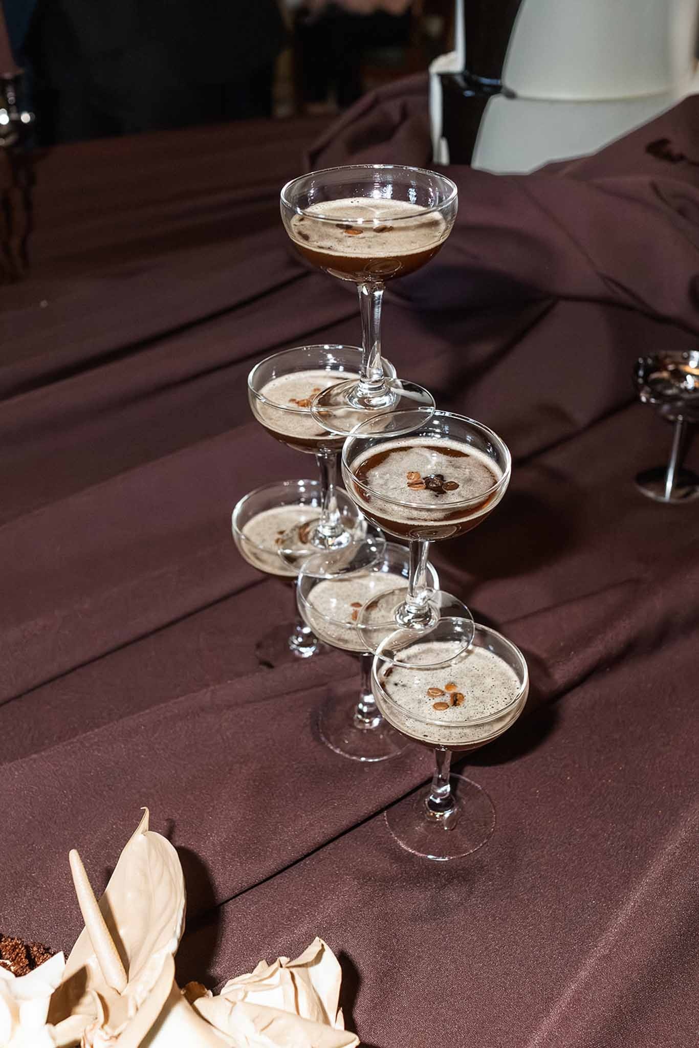 Espresso martini cocktails on dark satin at Chateau du Terral wedding reception