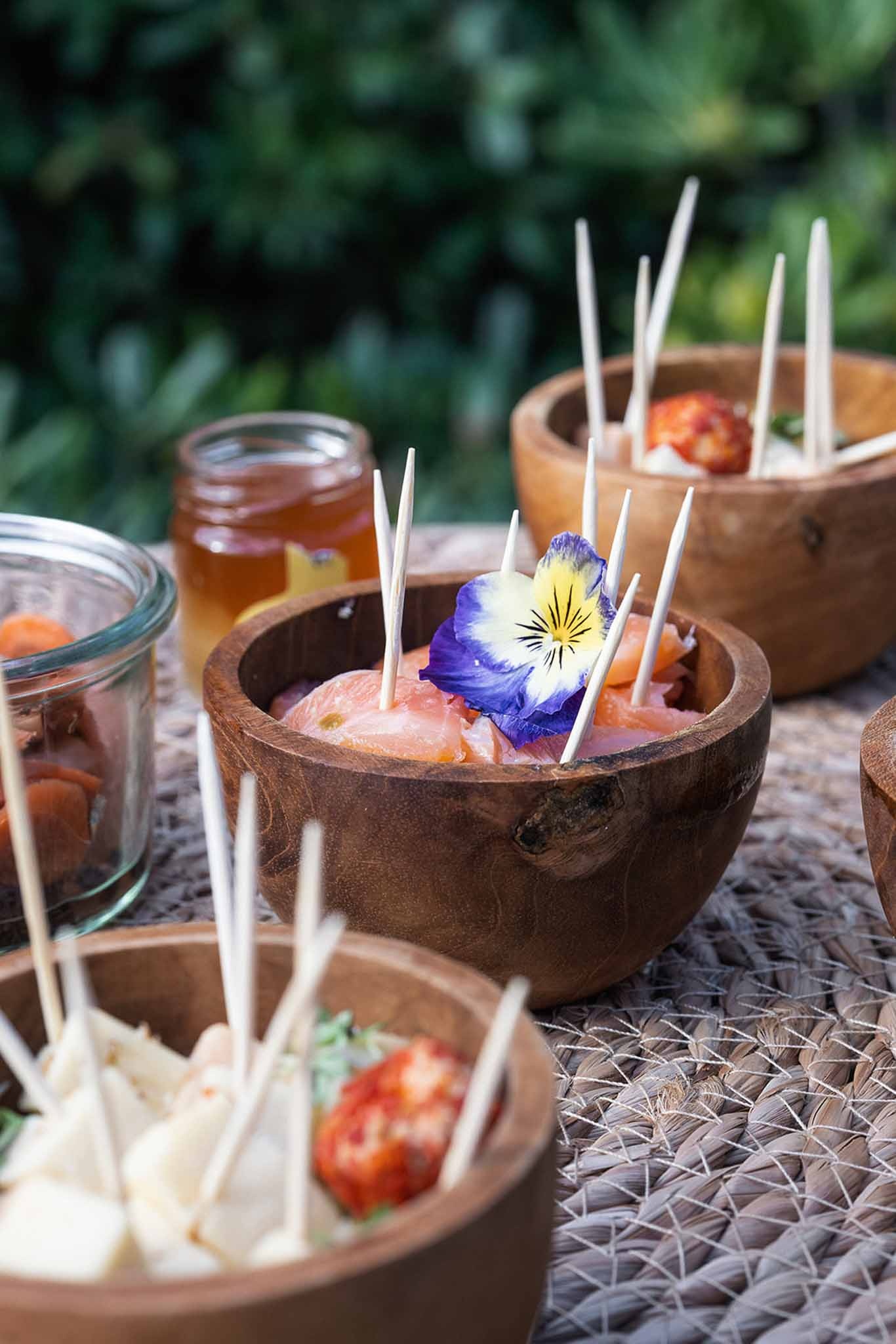 Rustic appetizers in wooden bowls with edible flowers at Chateau du Terral wedding