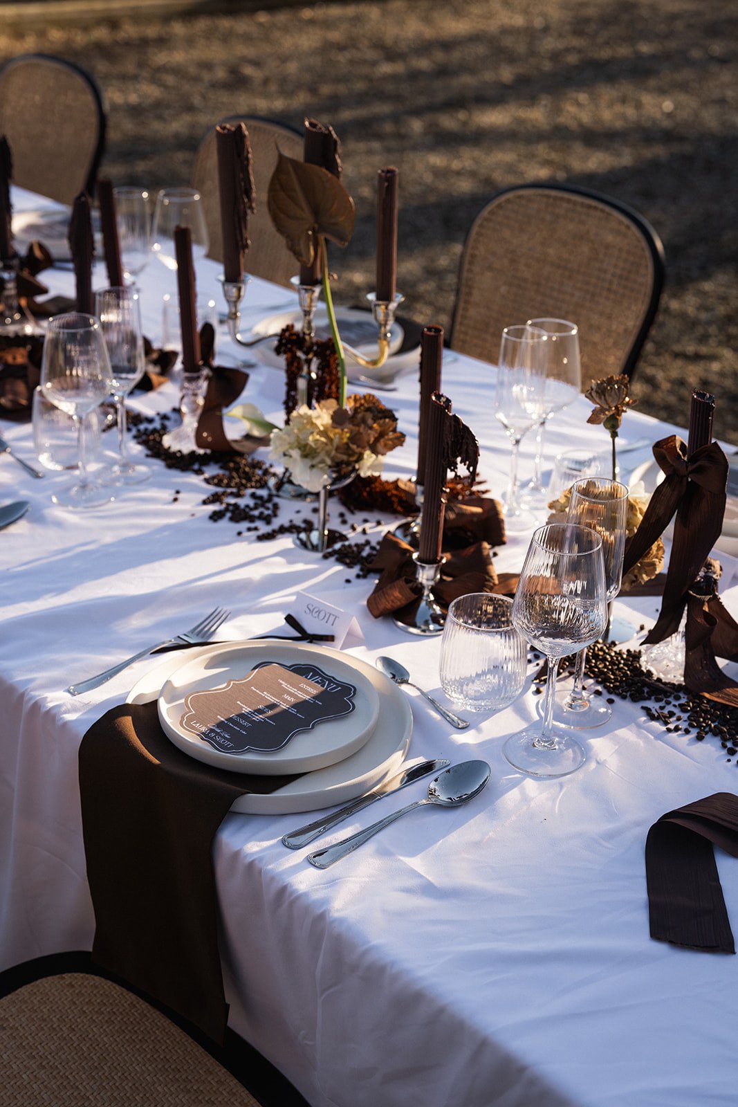 Reception place setting with brown taper candles and menu card at Chateau du Terral