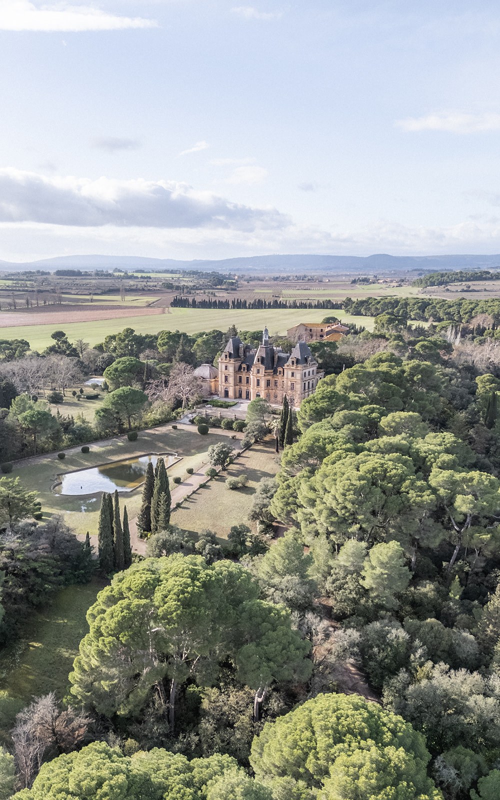 Aerial view of chateau and parkland with reflecting pool at Chateau du Terral