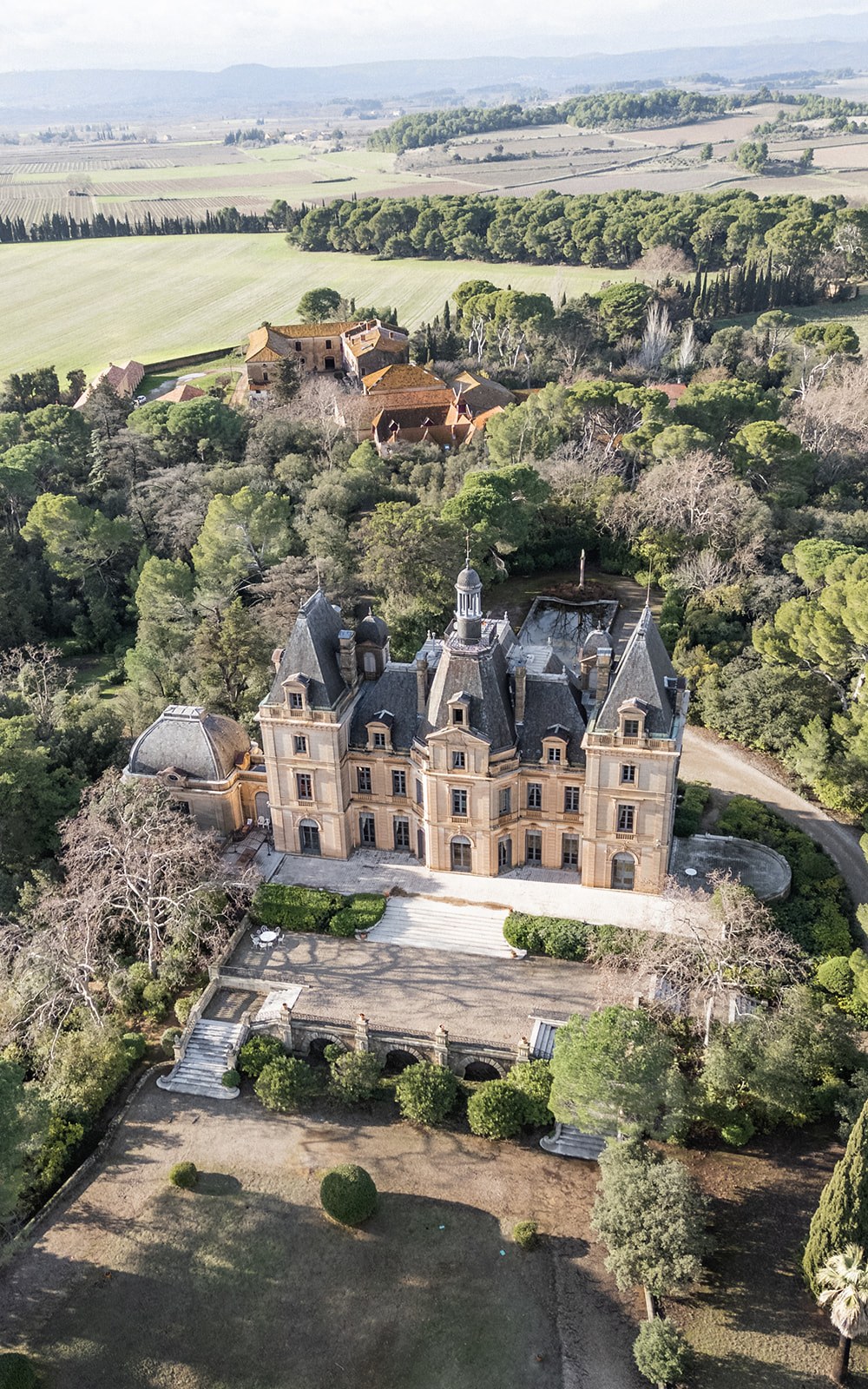 Aerial view of Chateau du Terral encircled by woodland and farmland at Chateau du Terral