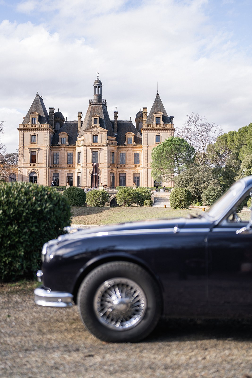 Vintage black Jaguar parked before Chateau du Terral facade at Chateau du Terral wedding