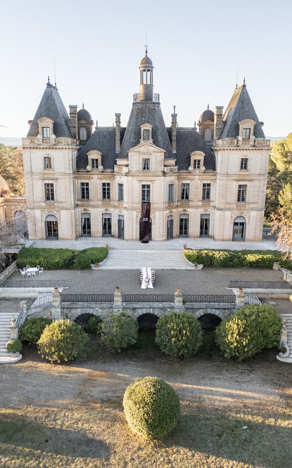 Wide chateau facade with arcaded terrace and ceremony seating at Chateau du Terral