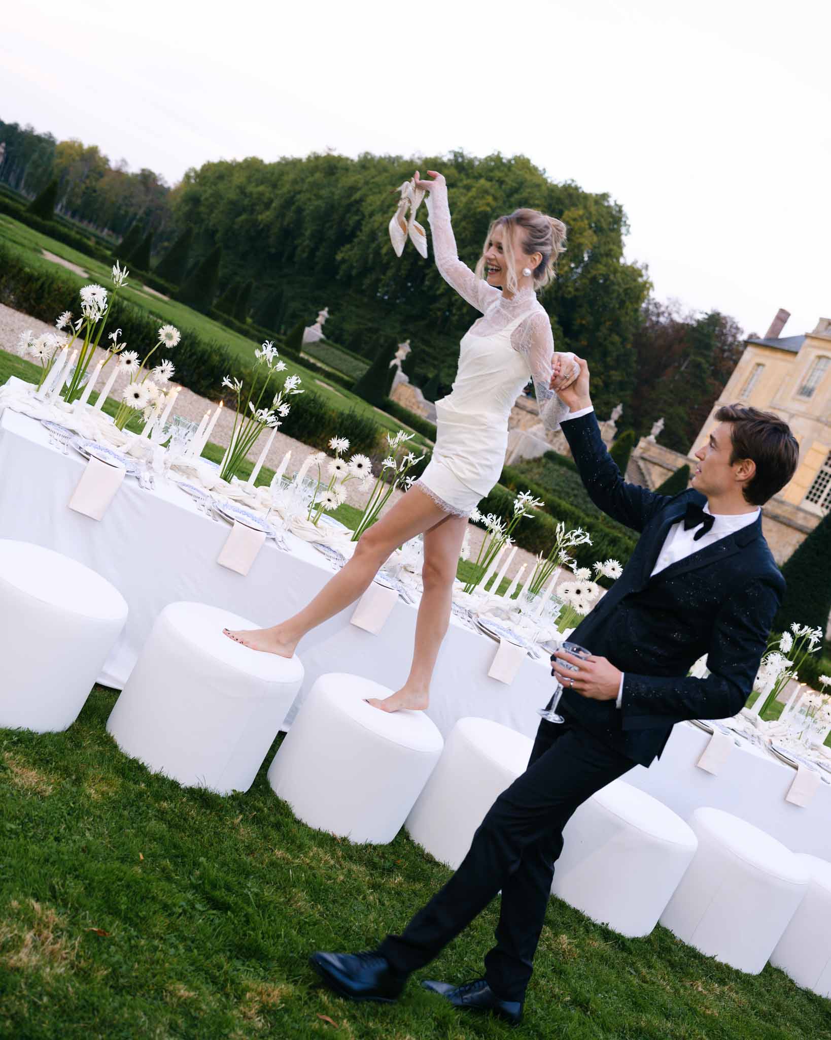 Bride in short evening dress walking arm in arm with groom