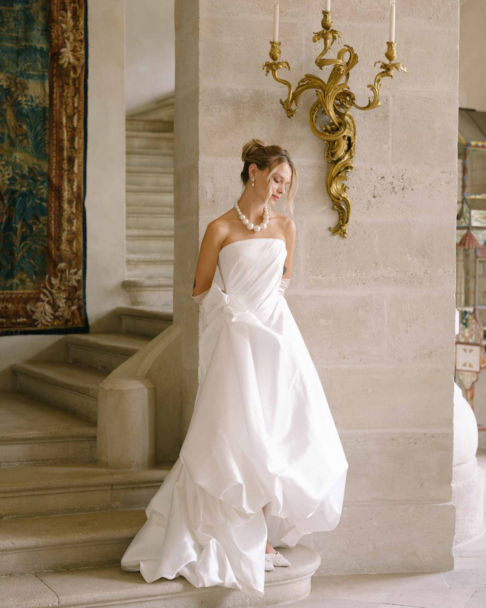 Editorial portrait of bride in strapless dress with pearl necklace