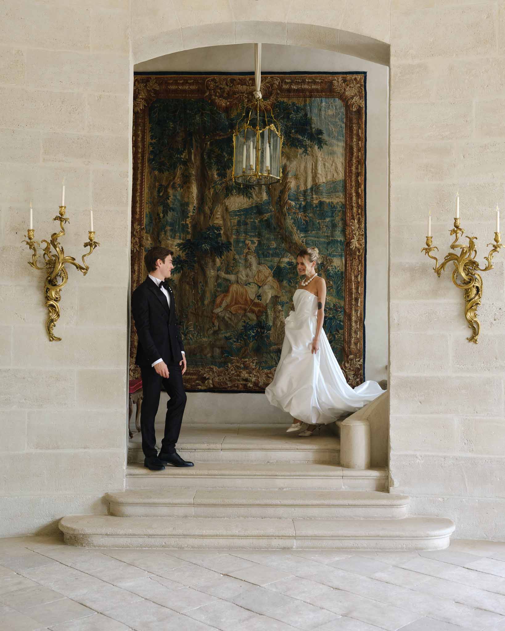 First look between bride and groom on the chateau staircase