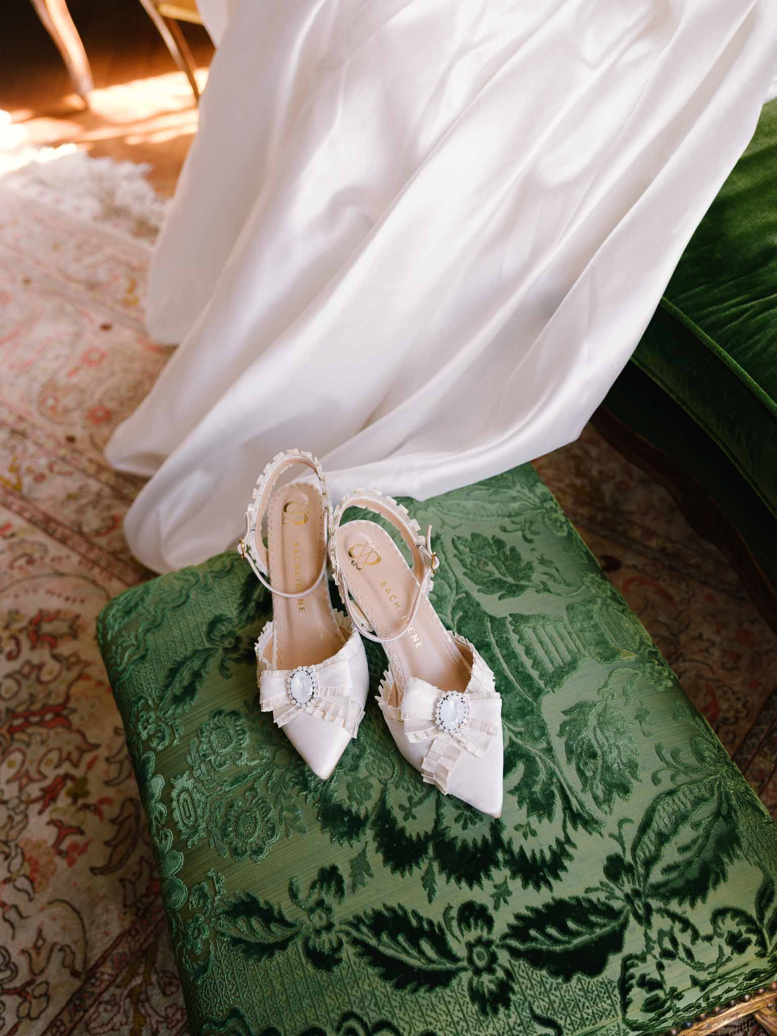 Close-up of pointed bridal shoes with ribbon ties