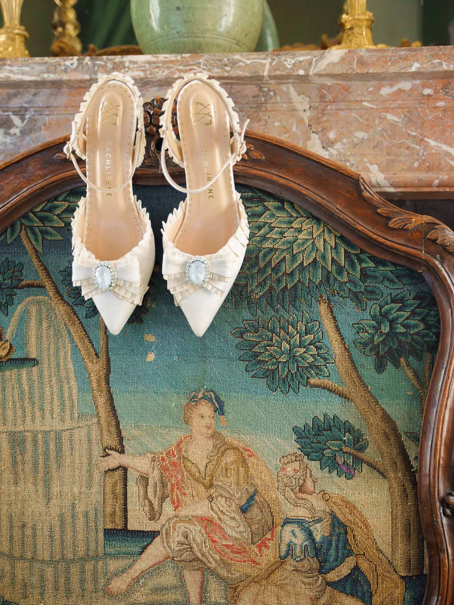 Bridal shoes displayed on ornate vintage chair