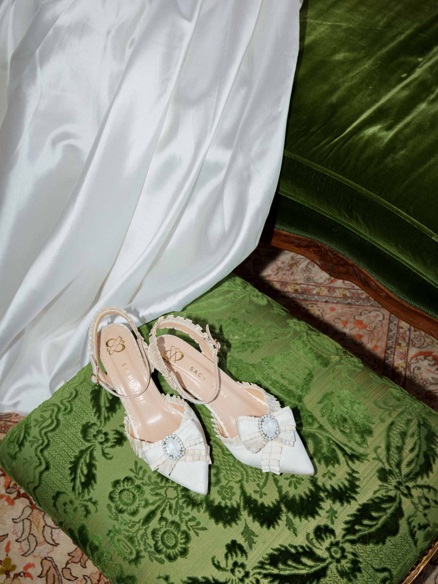 Bridal shoes resting on an embroidered vintage cushion