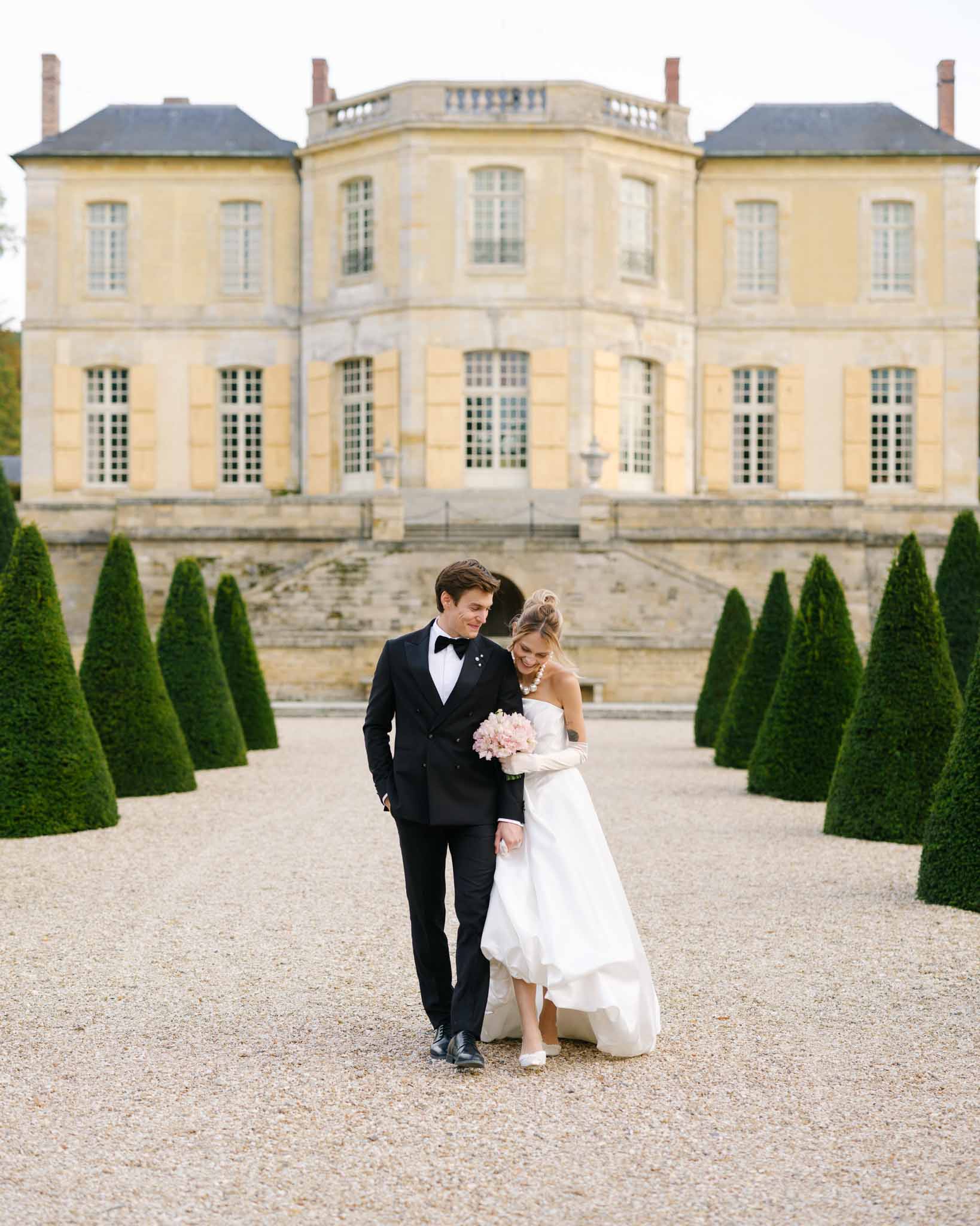 Couple walking arm in arm with Chateau de Villette behind them