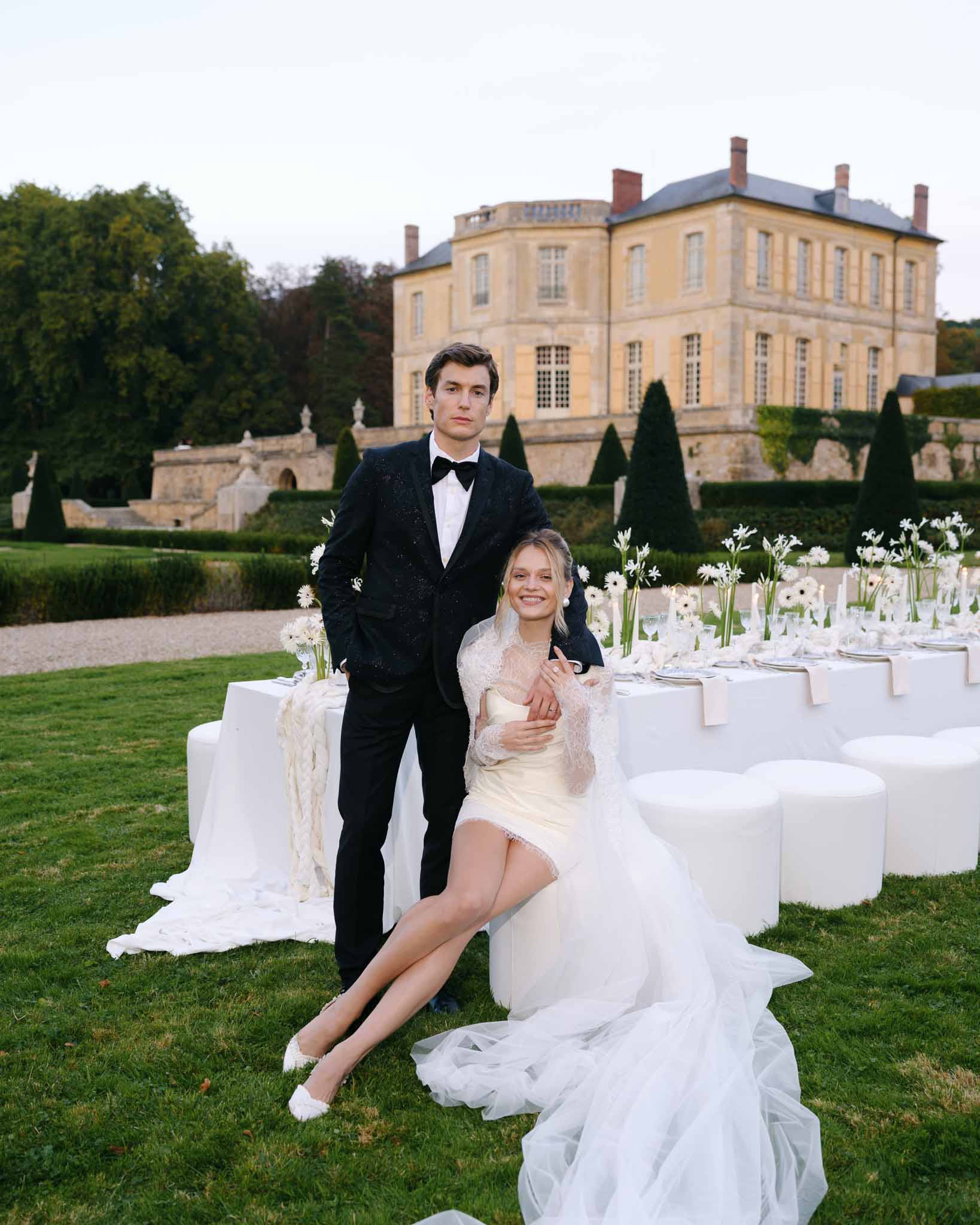 Couple posing together at the outdoor reception table