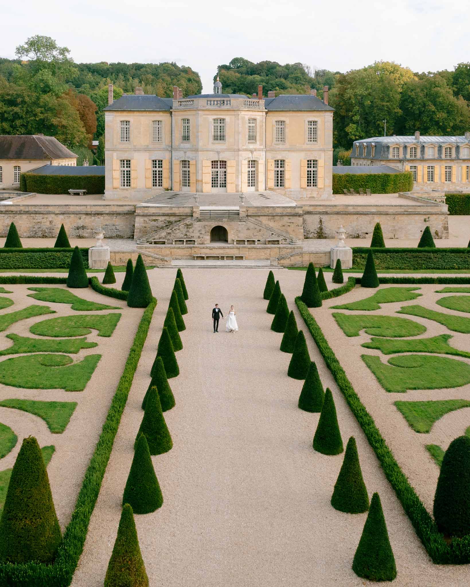 Couple walking together through the formal gardens of Chateau de Villette