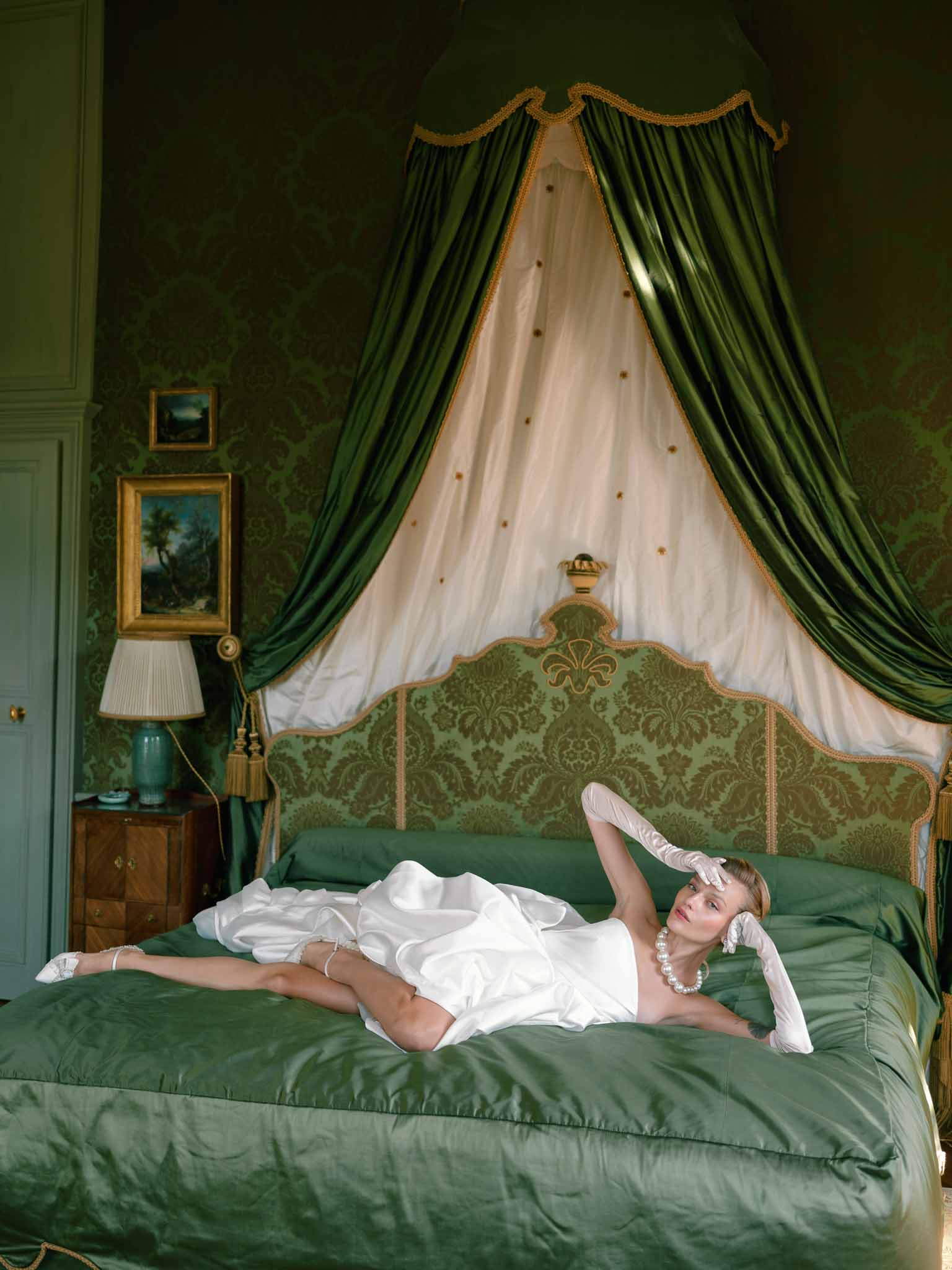 Bride reclining on an ornate vintage bed at Chateau de Villette