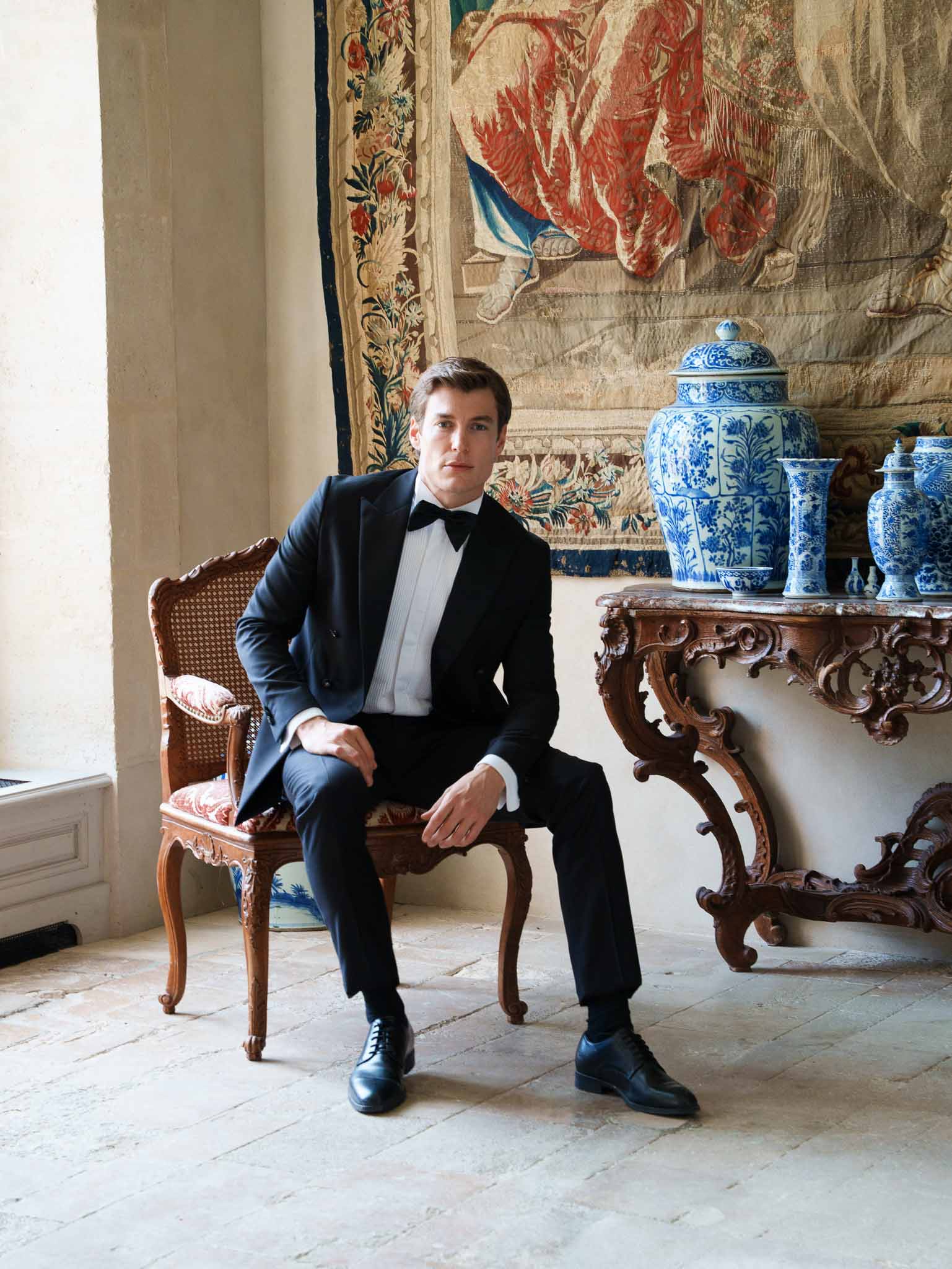 Groom seated in ornate period chair at Chateau de Villette