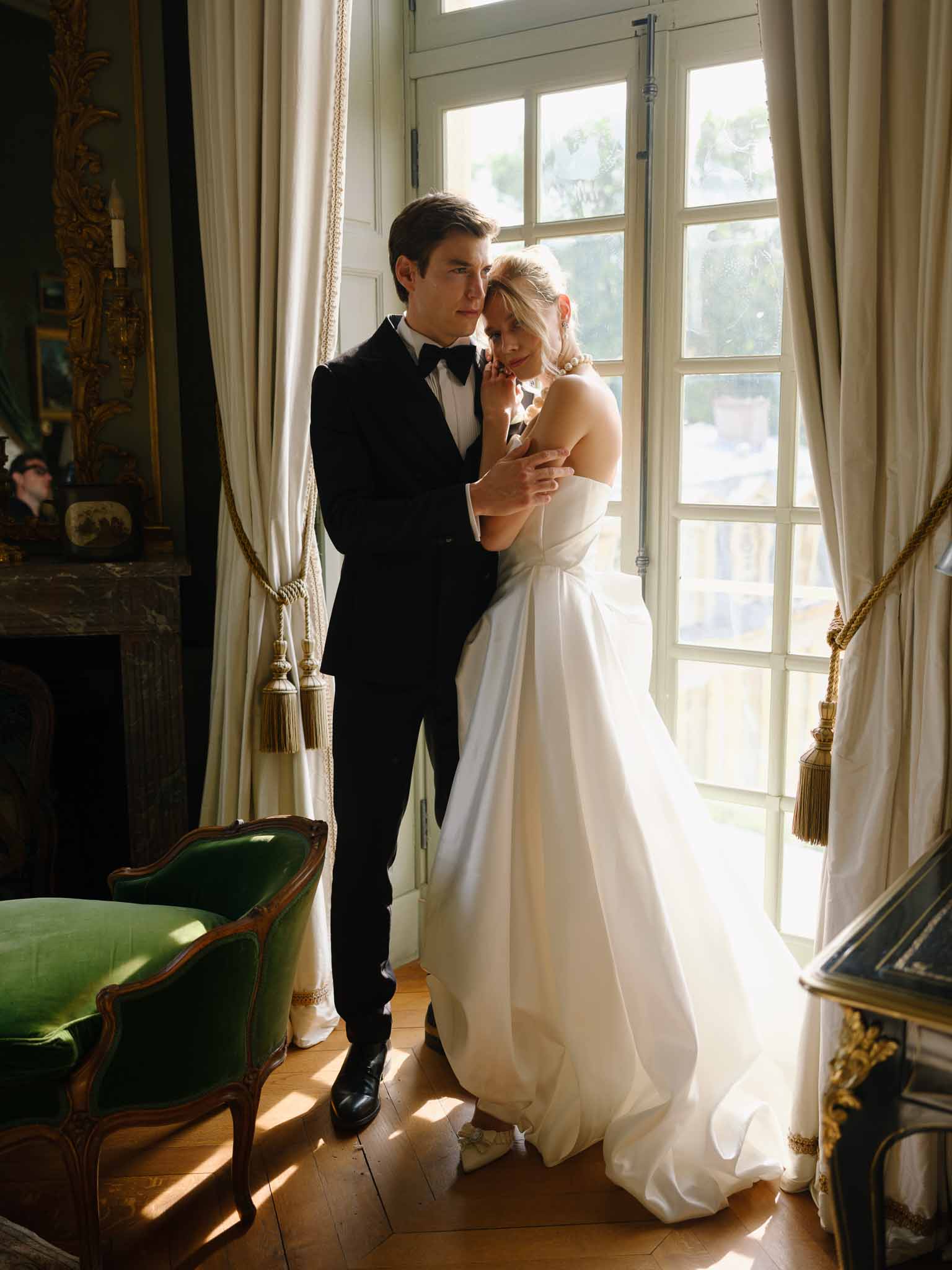 Couple embracing in warm golden hour light in period room